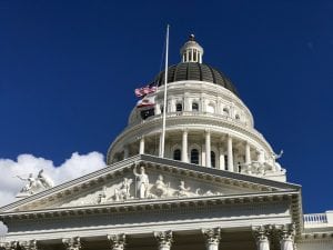 Photo of state capitol with flags at half-staff